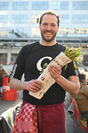 Julià Delos holding Calçots during the collaboration with Estrella Damm